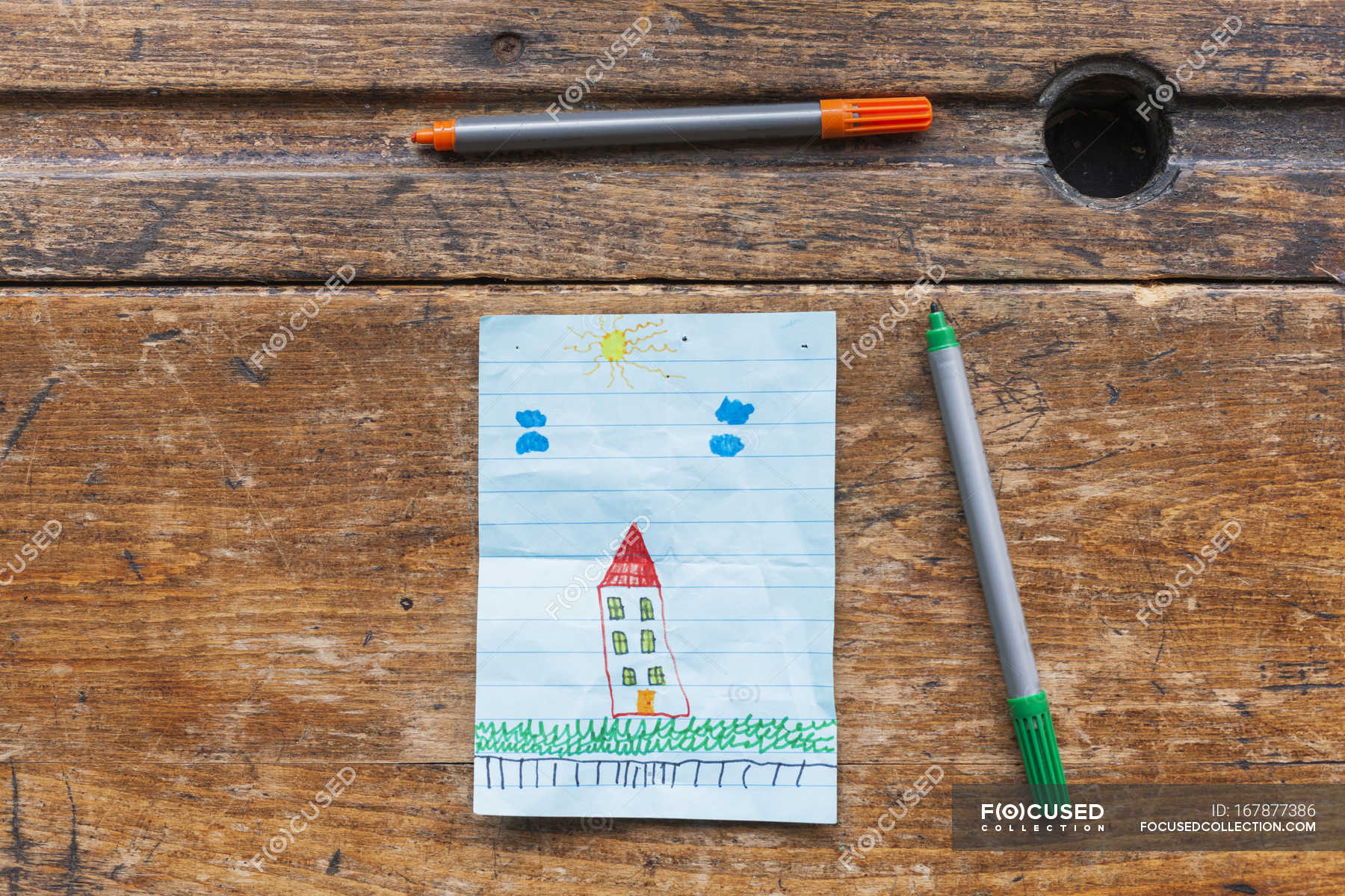 Childs Drawing Of House With Markers On Wooden Desk Copy Space