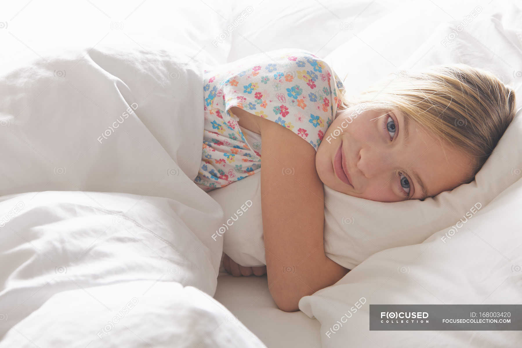 Portrait Of Blond Haired Girl Hugging Pillow In Bed Lying On Side Pre Adolescent Girl Stock Photo 168003420