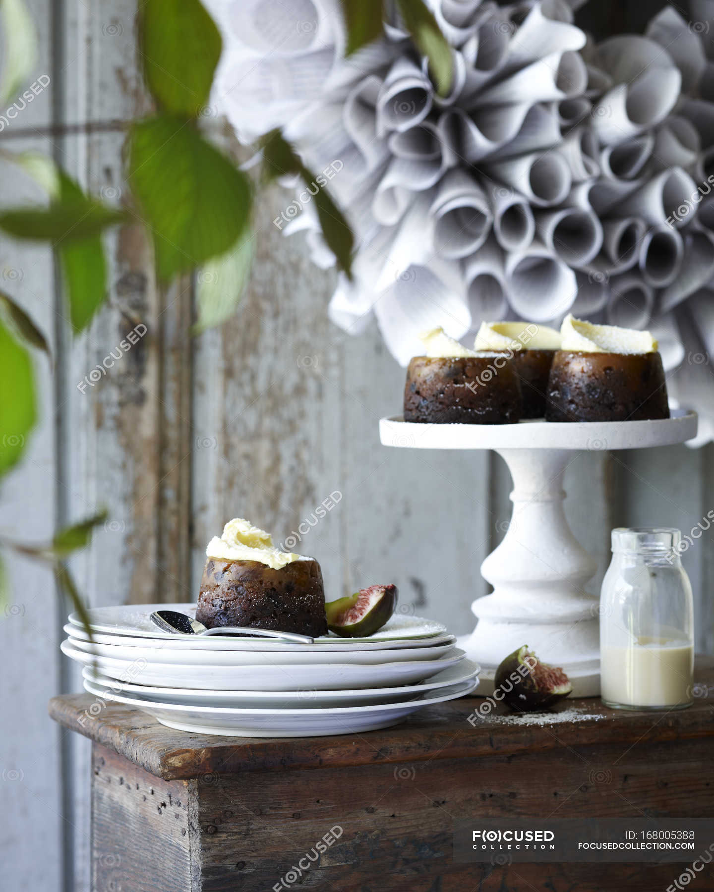 Mini christmas puddings on cakestand and plates on patio table — Focus ...