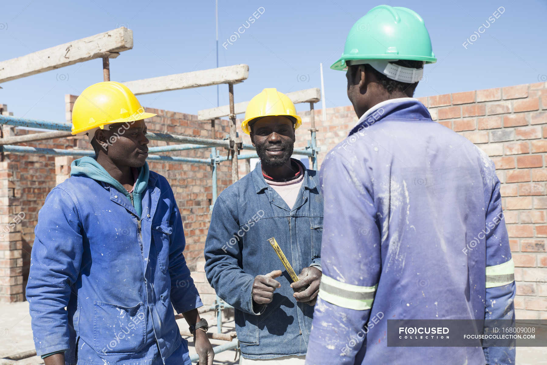 African Builders talking on construction site — Mature Adult, young