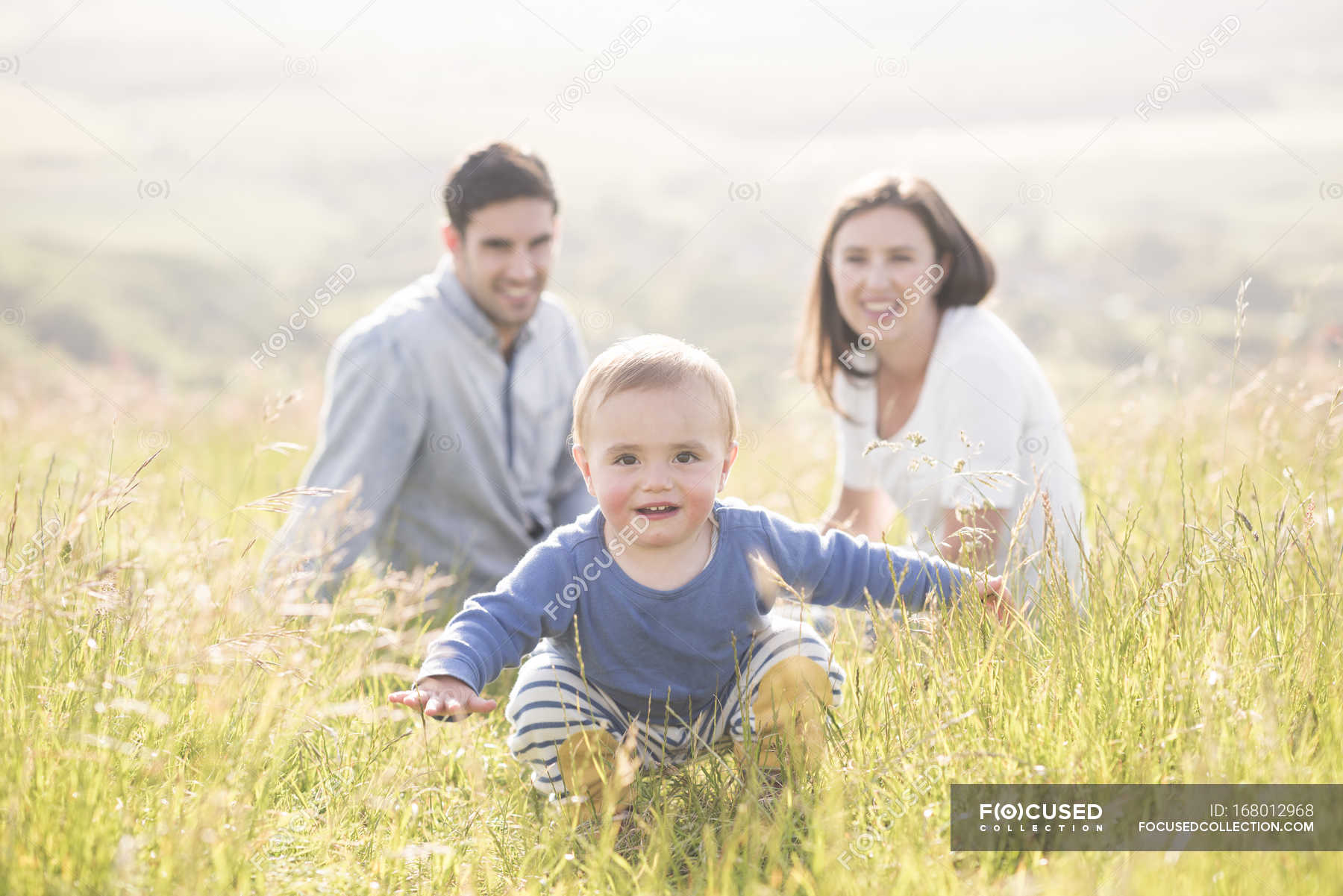 Portrait of young family in field — warm weather, son - Stock Photo