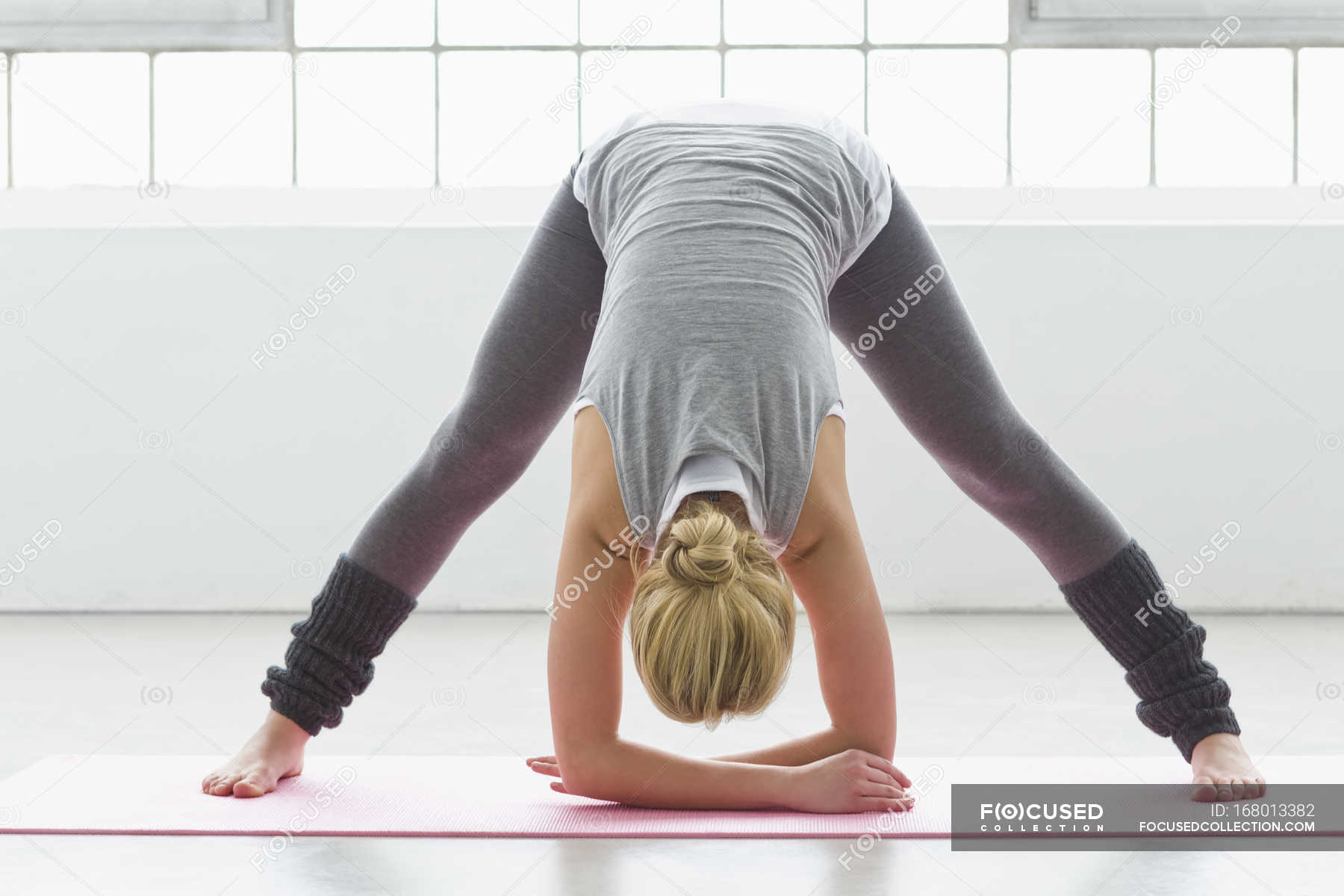 Young Woman In Yoga Pose Bending Forwards — Day One Person Stock