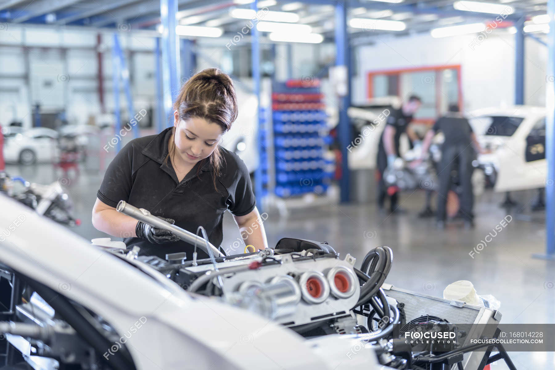 Female engineer assembles car in racing car factory — engineering,  automobile factory - Stock Photo | #168014228