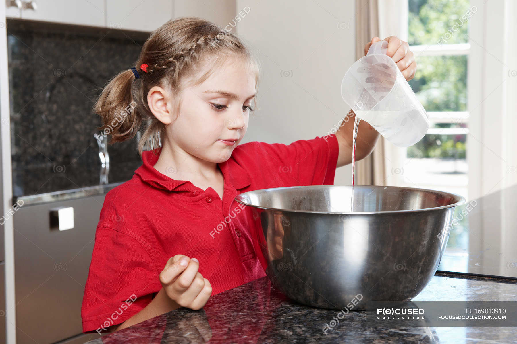 Girl Pouring Water In To Mixing Bowl Kid Counter Stock Photo