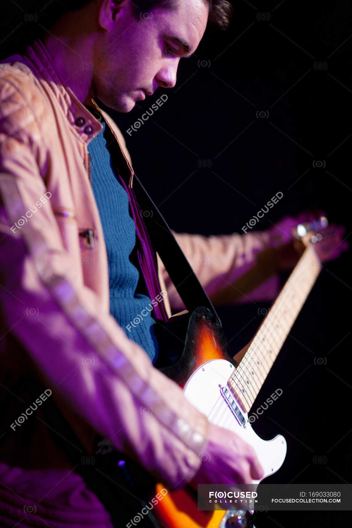 Close Up Of Man Playing Guitar Hands Spotlight Stock Photo