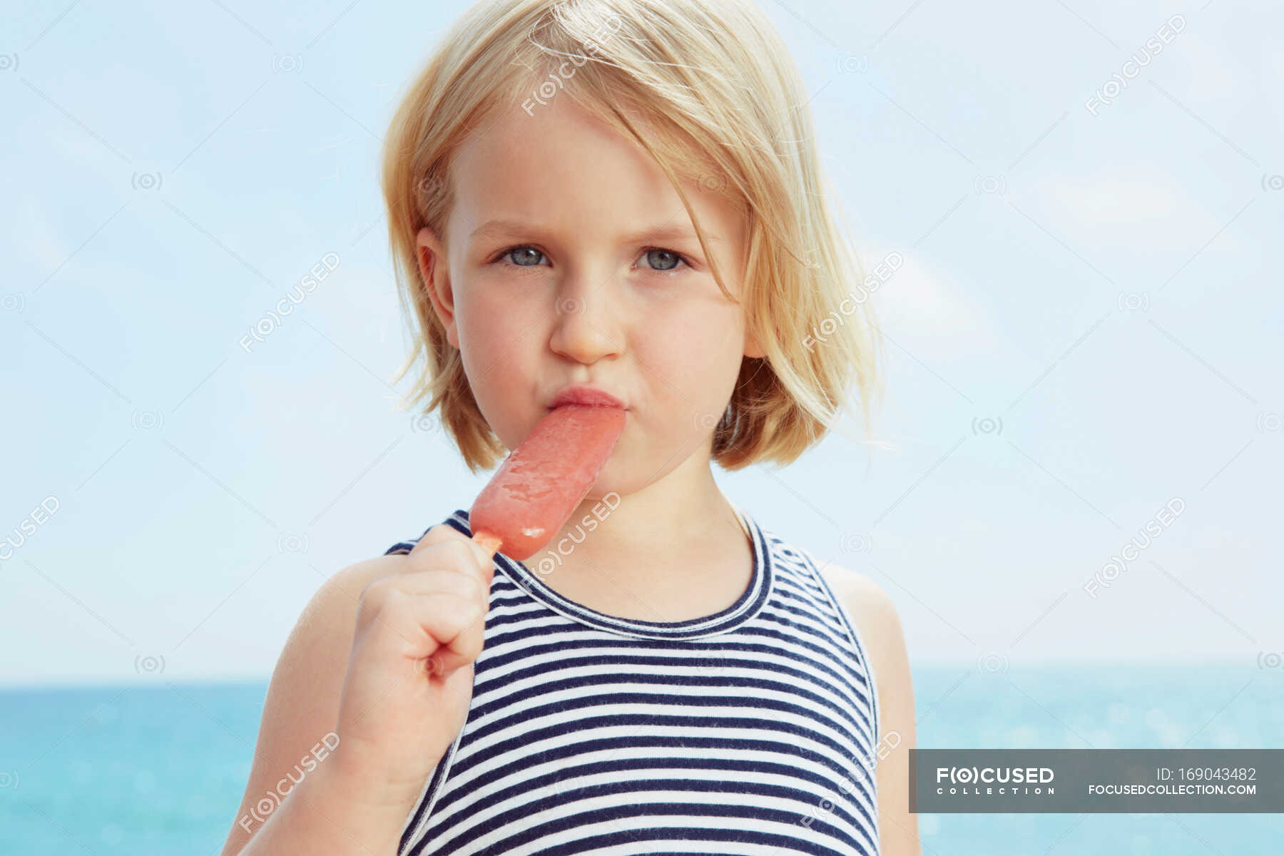 Child eating ice lolly — top, portrait - Stock Photo | #169043482