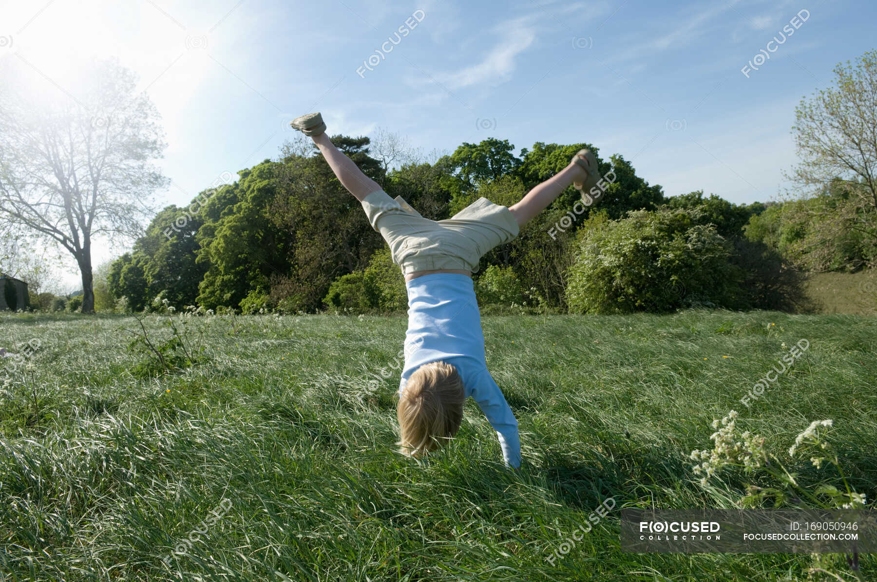 Boy doing handstand in field — vitality, people - Stock Photo | #169050946