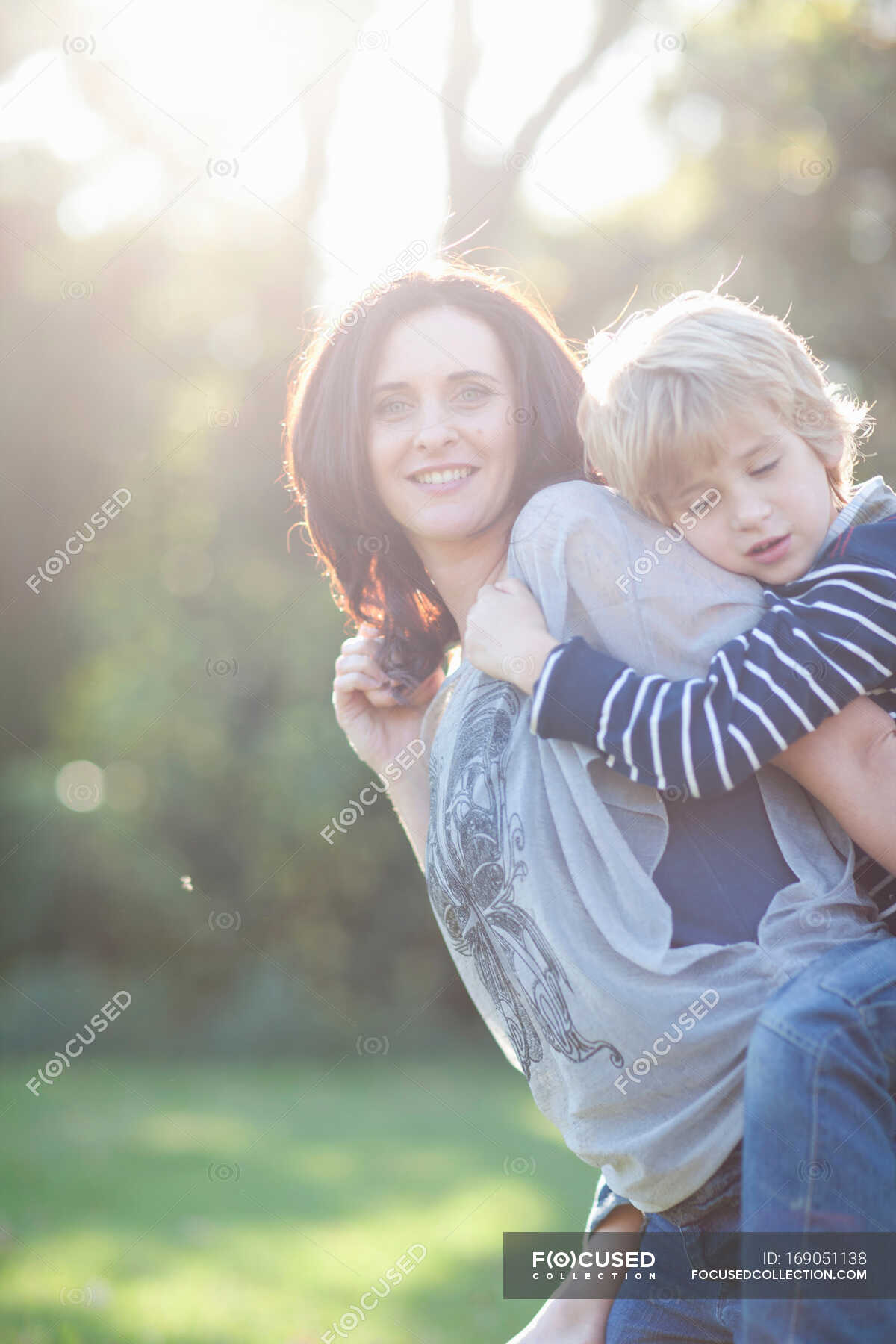 Mother giving son piggyback — lifestyle, garden - Stock Photo | #169051138