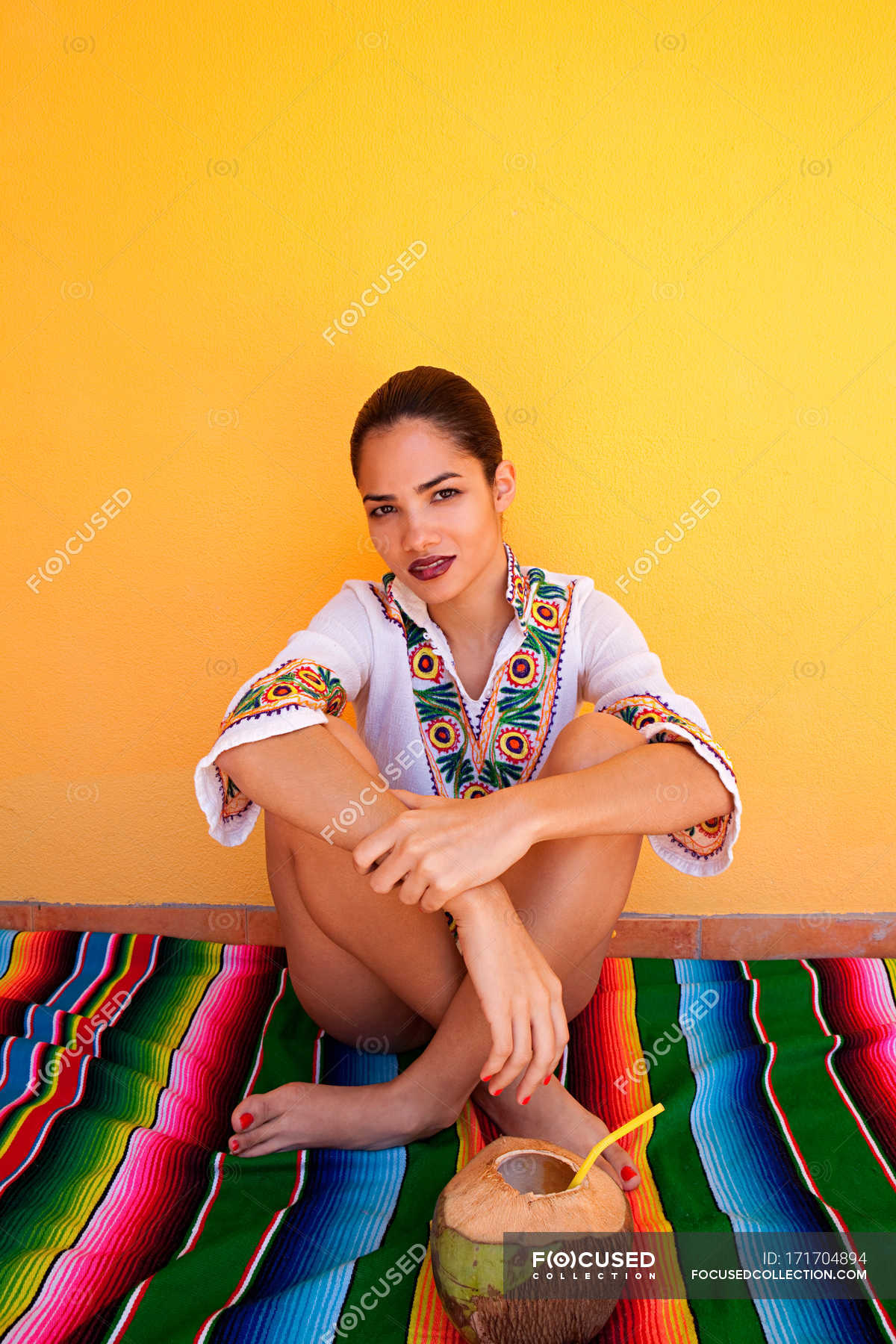 Woman sitting on ethnic style blanket with tropical fruit juice — Top ...