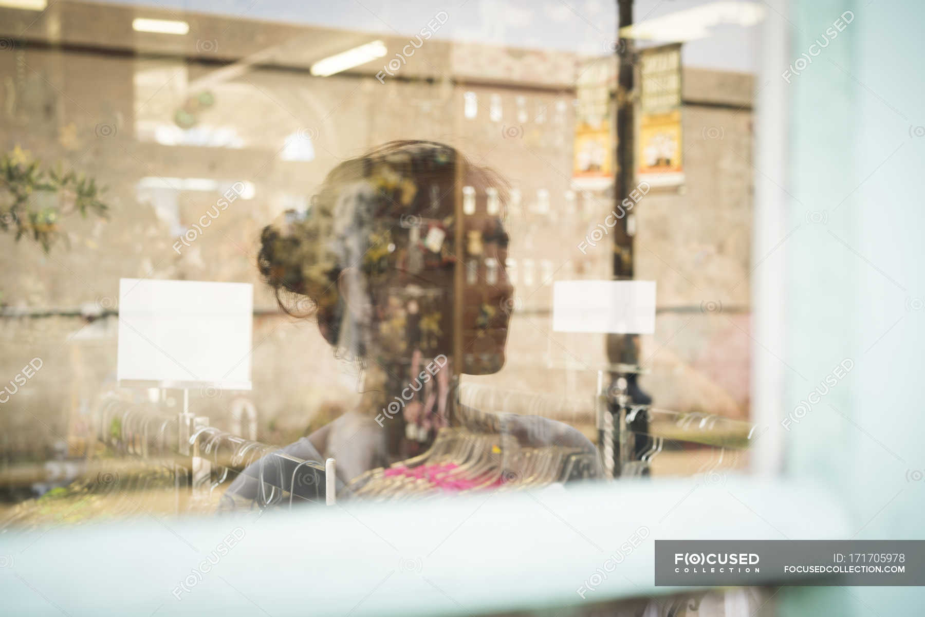 Reflection of woman in shop window — caucasian, daytime - Stock Photo