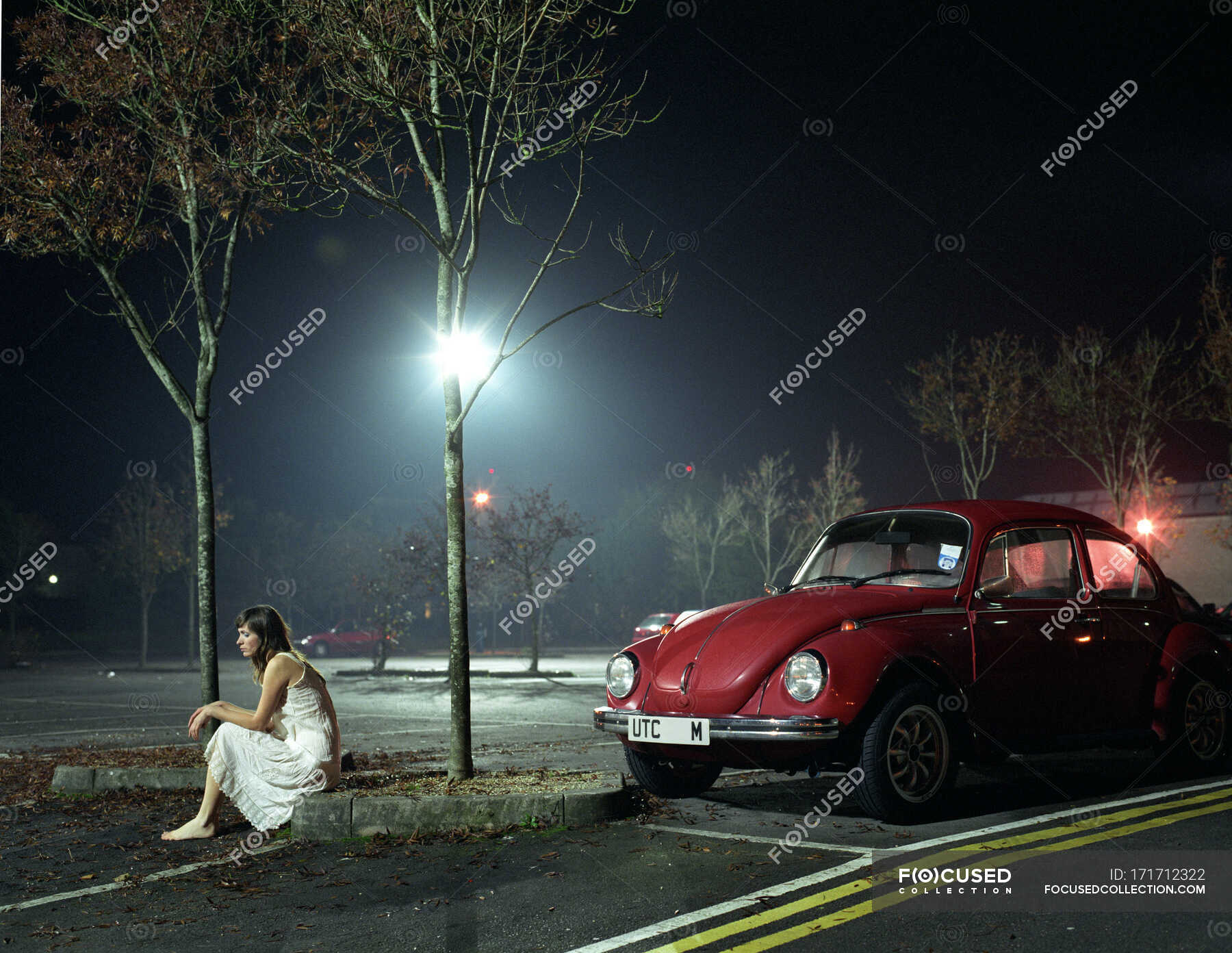 https://st.focusedcollection.com/13397678/i/1800/focused_171712322-stock-photo-woman-sitting-car-park-night.jpg