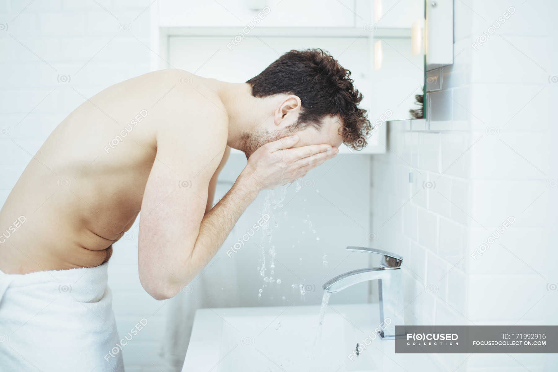 washing face in bathroom sink