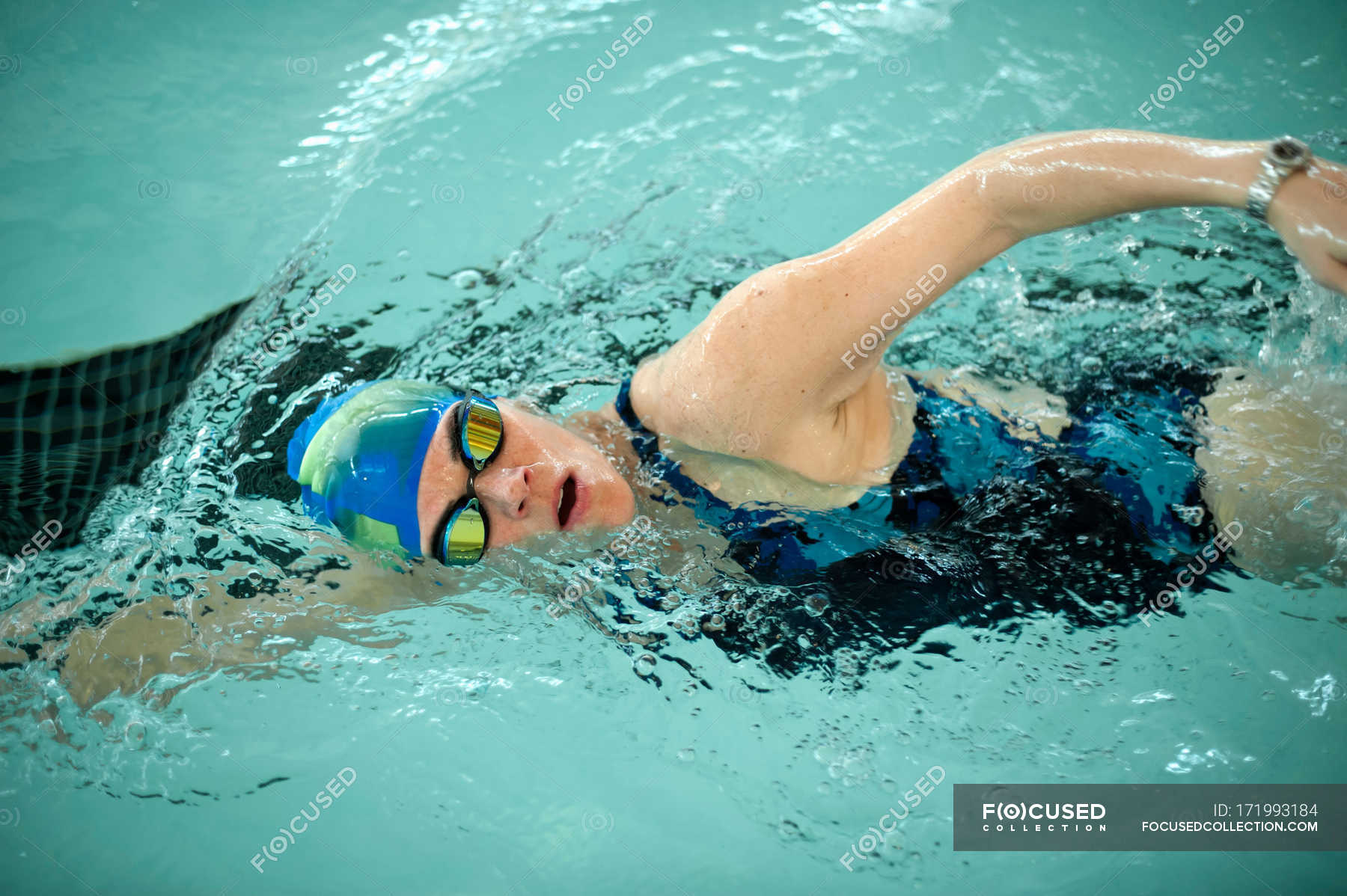 woman-doing-laps-in-swimming-pool-side-view-vitality-stock-photo