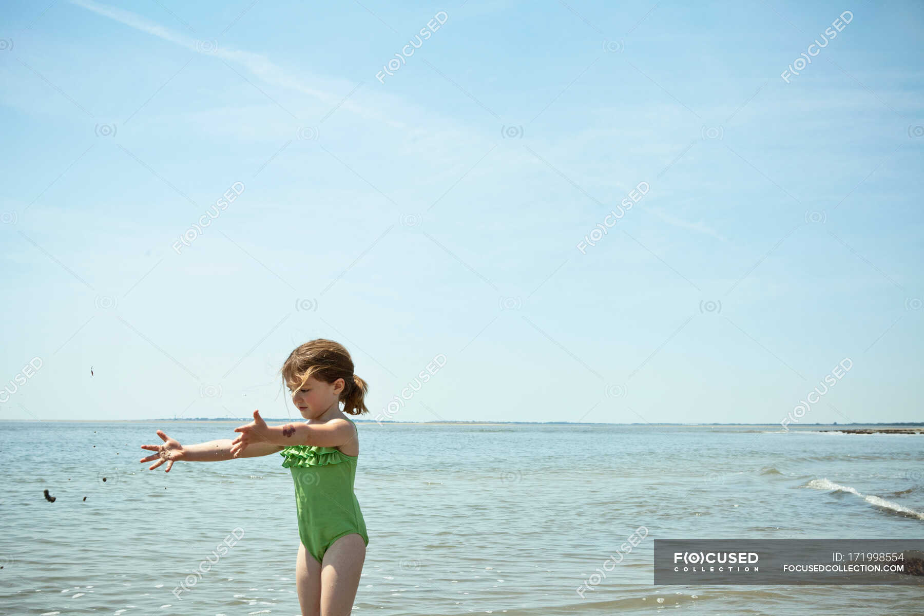 Girl playing with sand on beach — travel destination, arms open - Stock ...