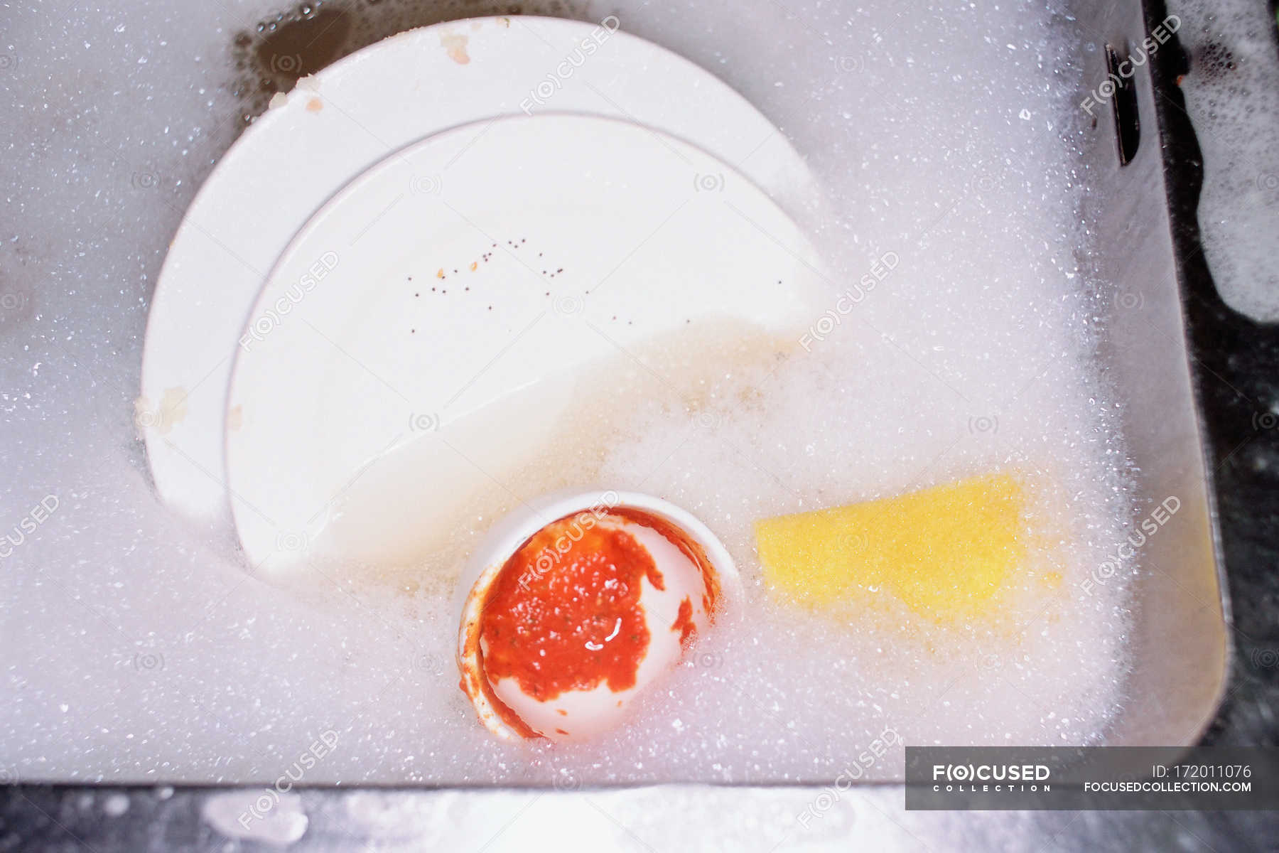 Dishes soaking in soapy water with foam — sink, chores Stock Photo
