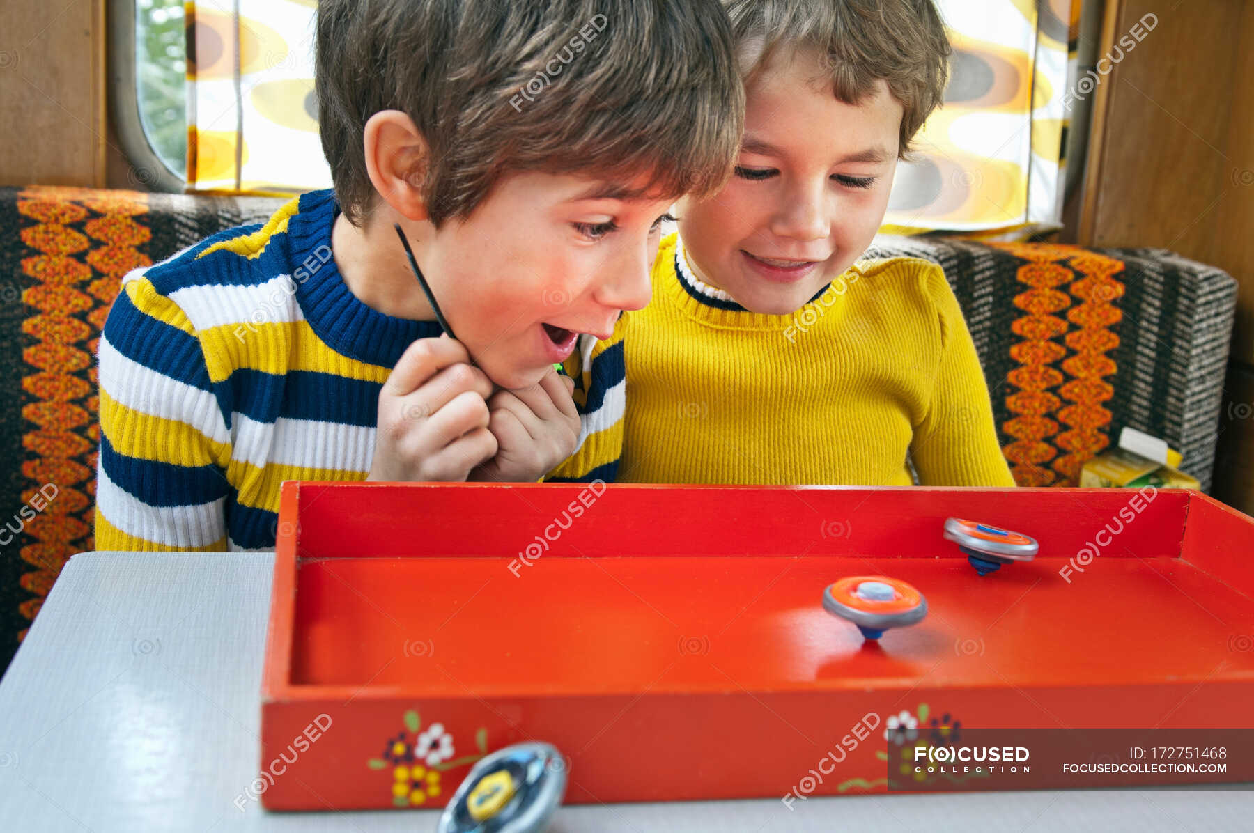 Two Boys Playing With Spinning Tops In Caravan — Game, Kitsch - Stock 