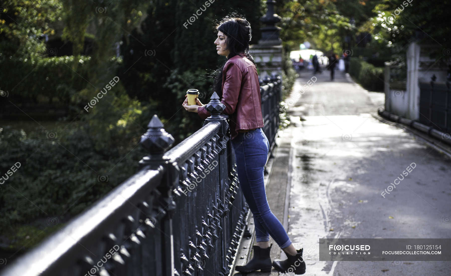 Young woman leaning on railing, looking at view — footbridge, 20 to 24