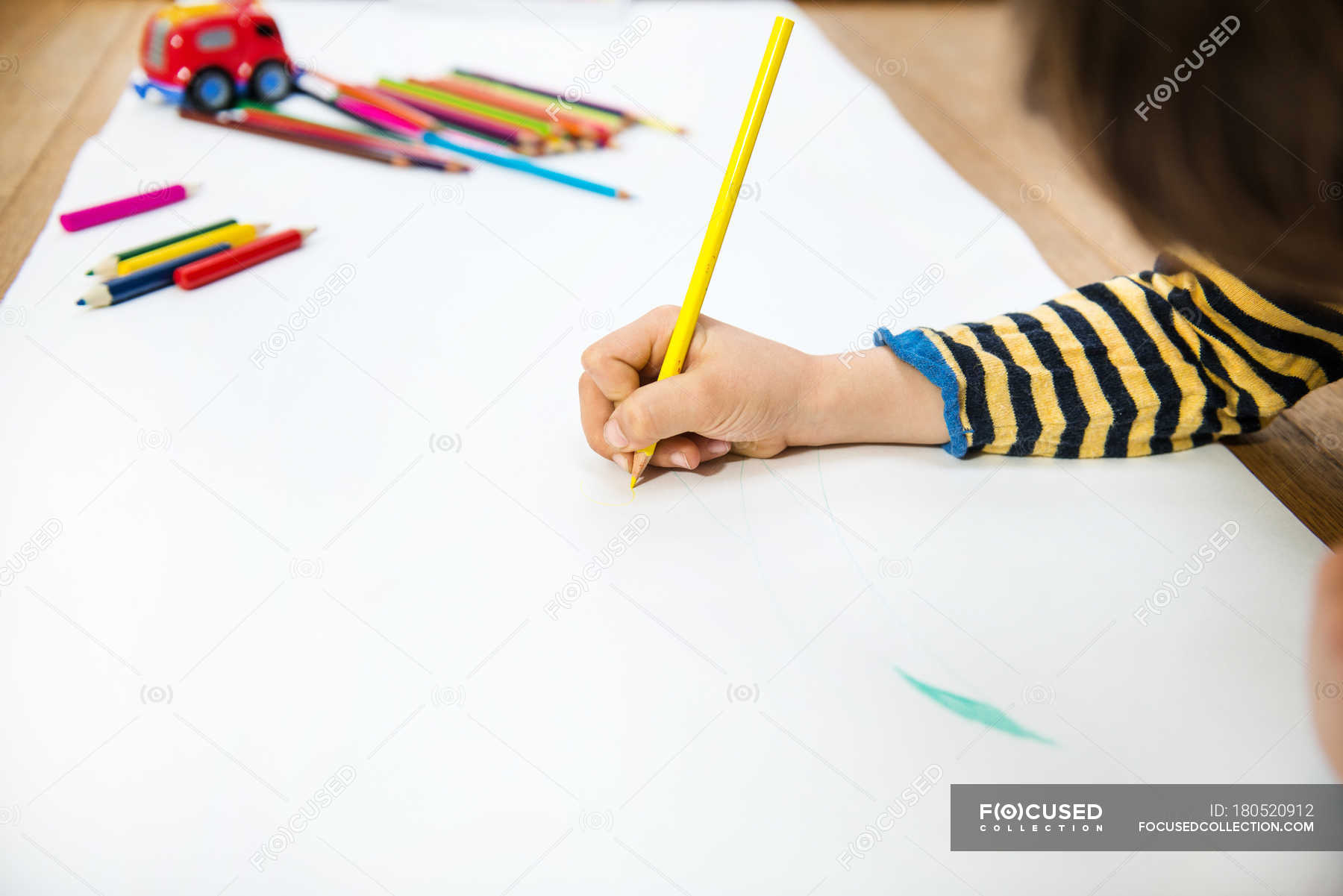 Mano del ragazzo sdraiato sul pavimento che disegna su carta lunga —  Pavimento in legno, Matita colorata - Stock Photo