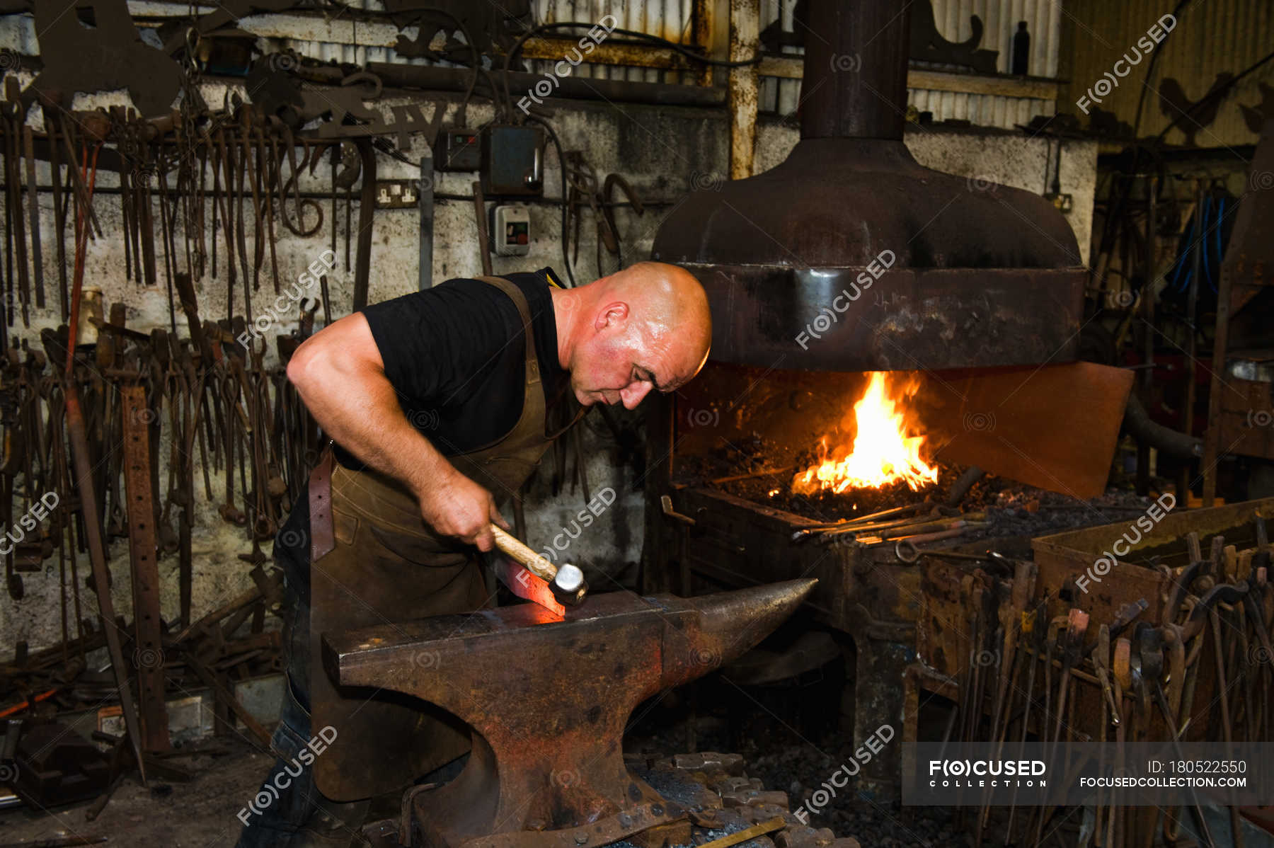 caucasian-male-blacksmith-at-work-in-smith-focus-concept