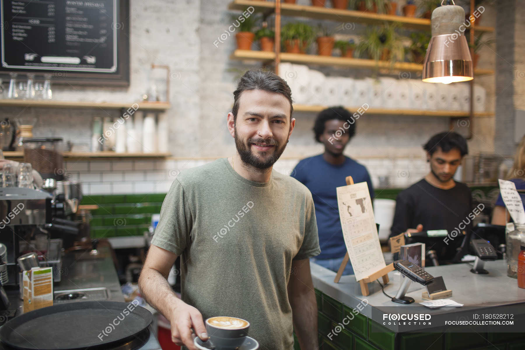 Portrait of male barista serving coffee in cafe — african ethnicity ...