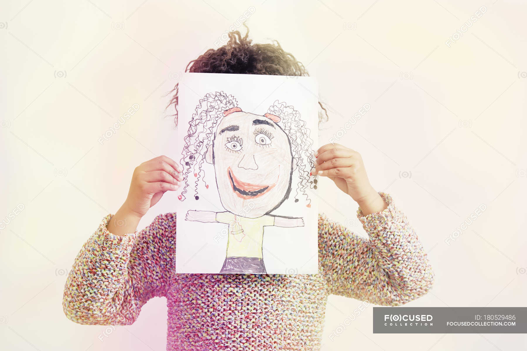 Portrait Of Young Girl Holding Drawing Covering Face Front View Happiness Stock Photo