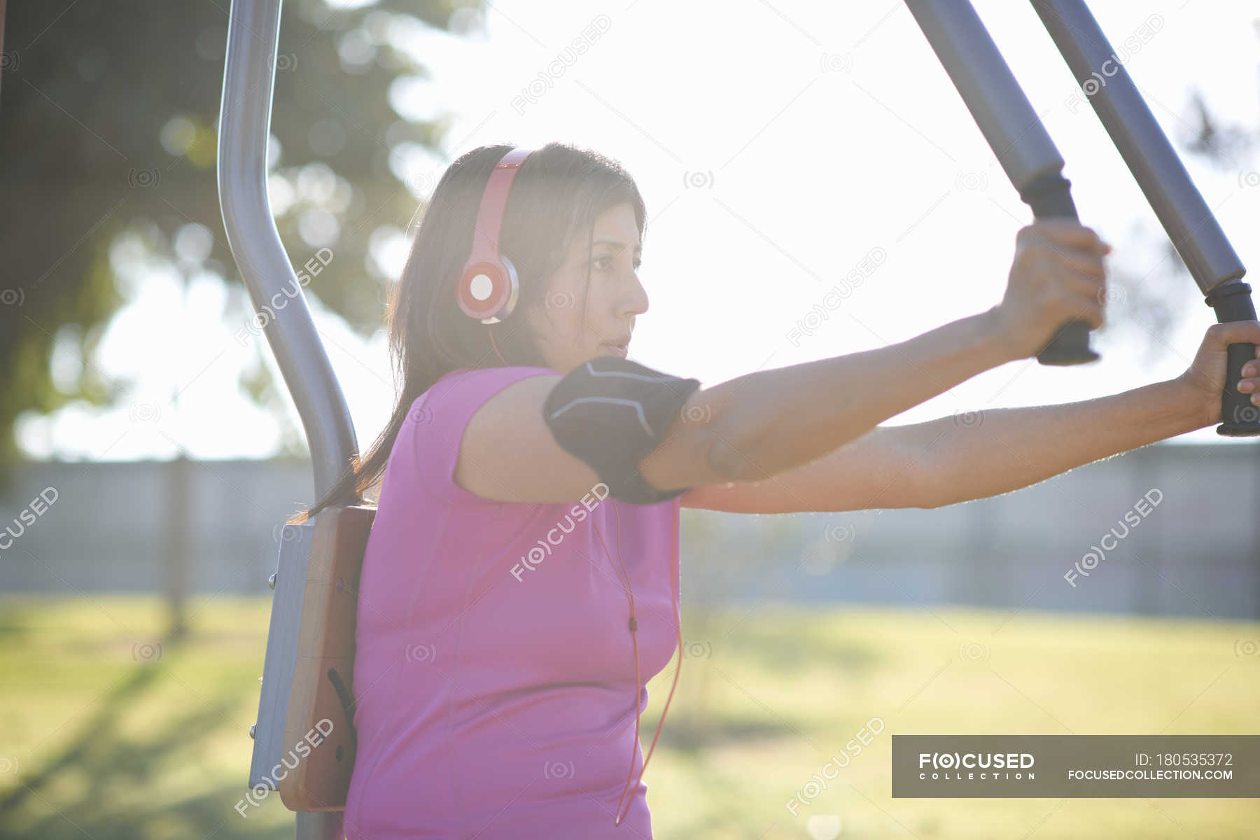 Side View Of Mature Woman Wearing Headphones Using Outdoor Pec