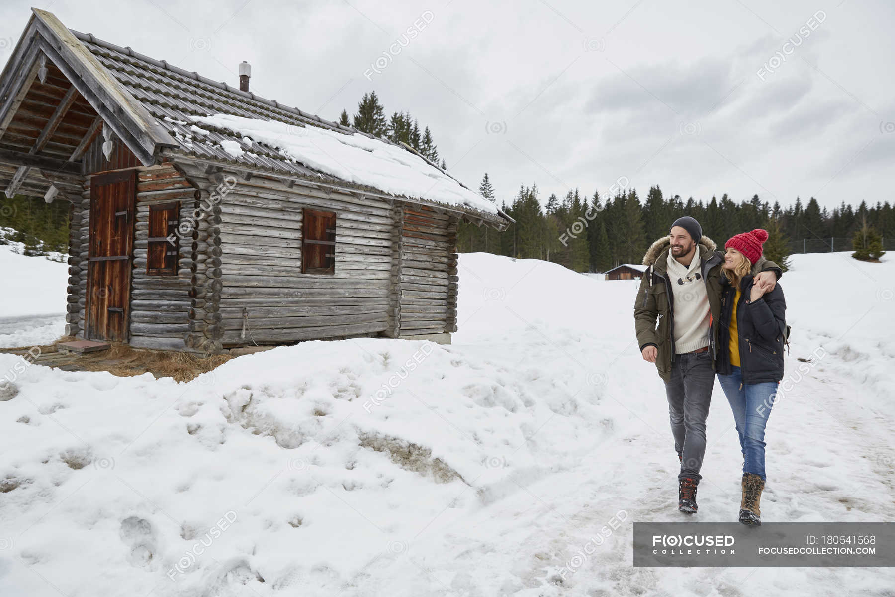 Couple Hiking From Log Cabin In Winter Elmau Bavaria Germany