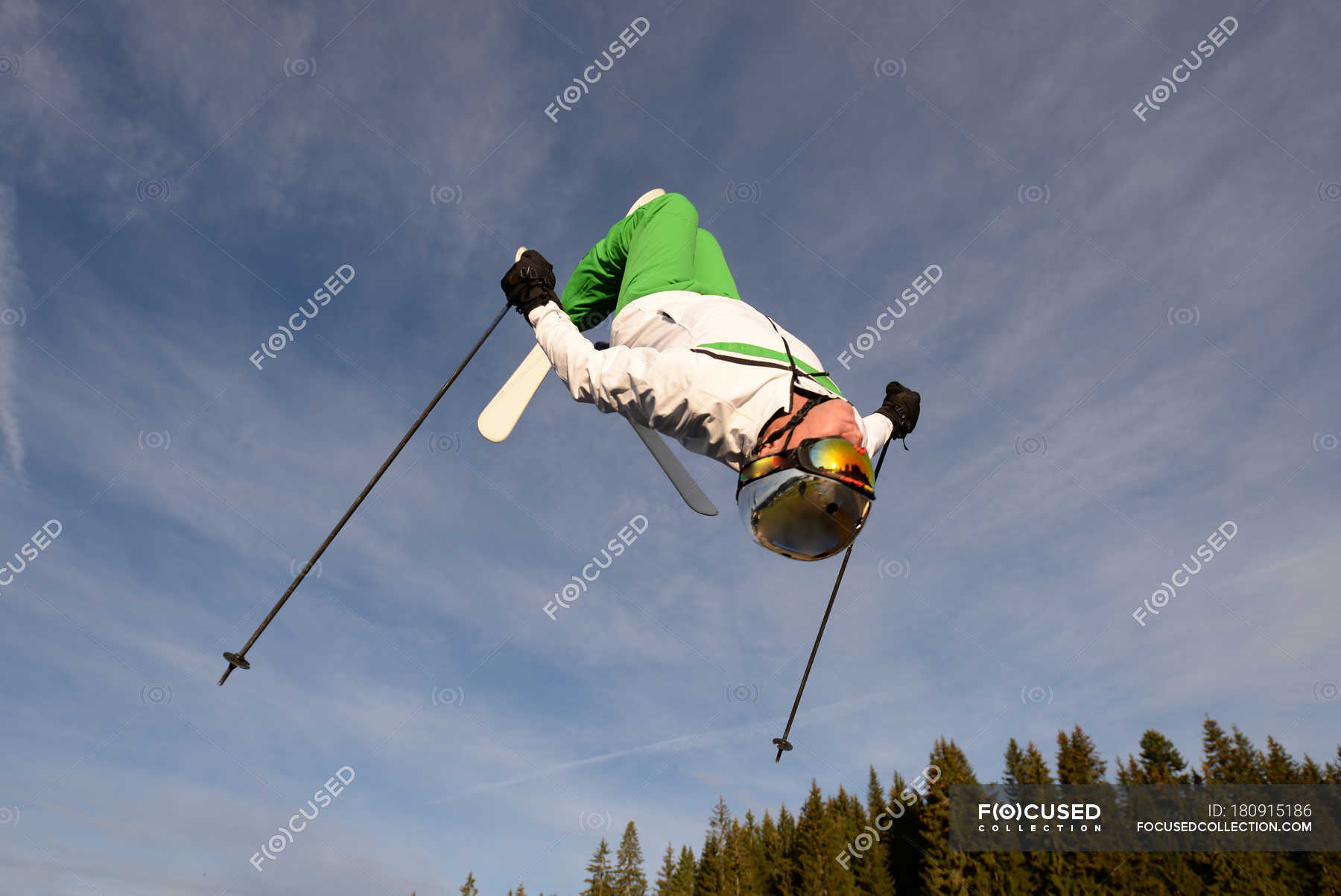 Man Backflipping Upside Down Mid Air Whilst Freestyle Ski Jumping Skiing Helmet Low Angle View Stock Photo