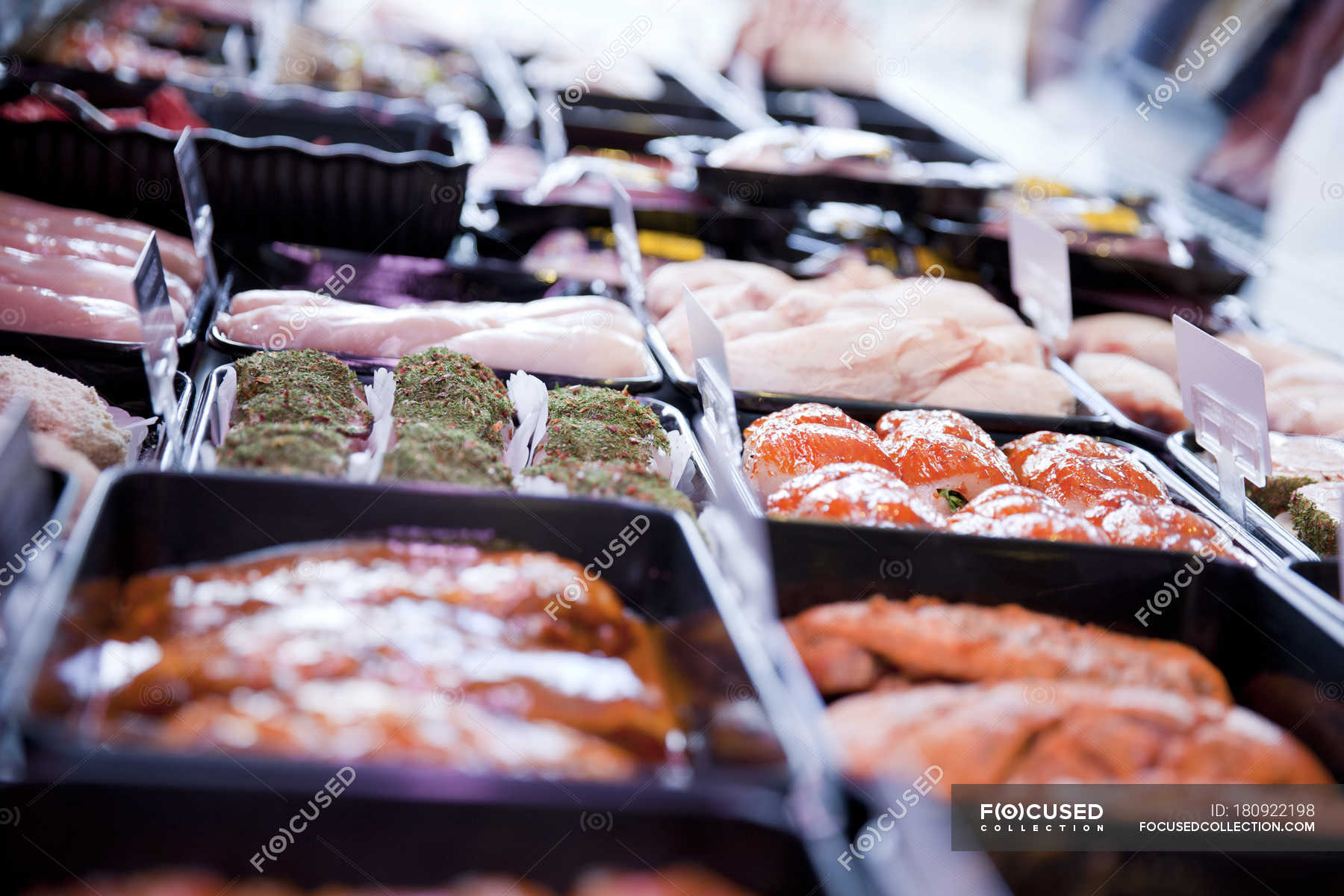 Variety of fresh meat products in refrigerator at butchers shop — Food