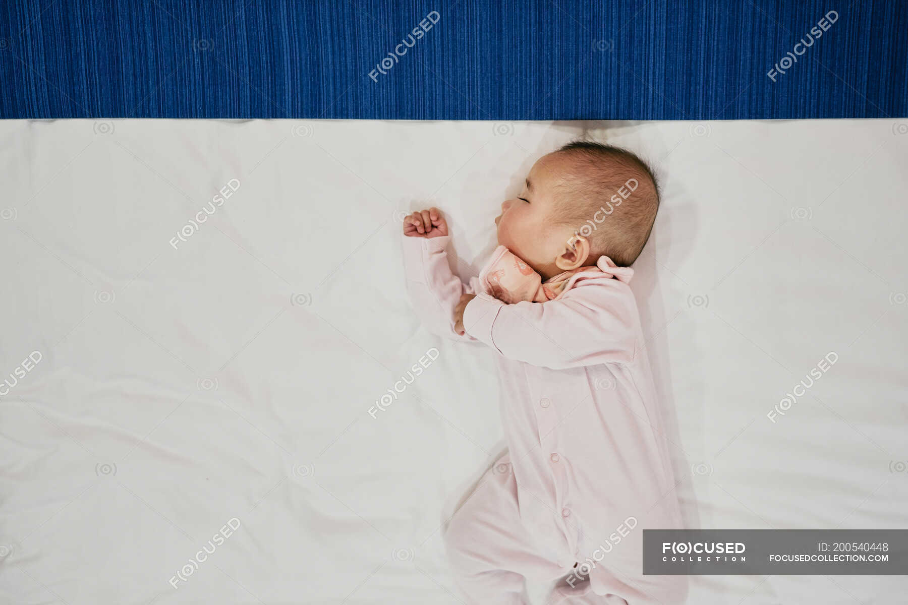 Baby girl sleeping on bed, overhead view — innocence, female Stock