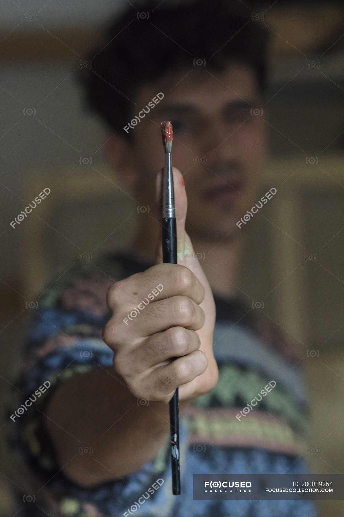 Male artist holding paintbrush in hand — Focus On Foreground, people ...