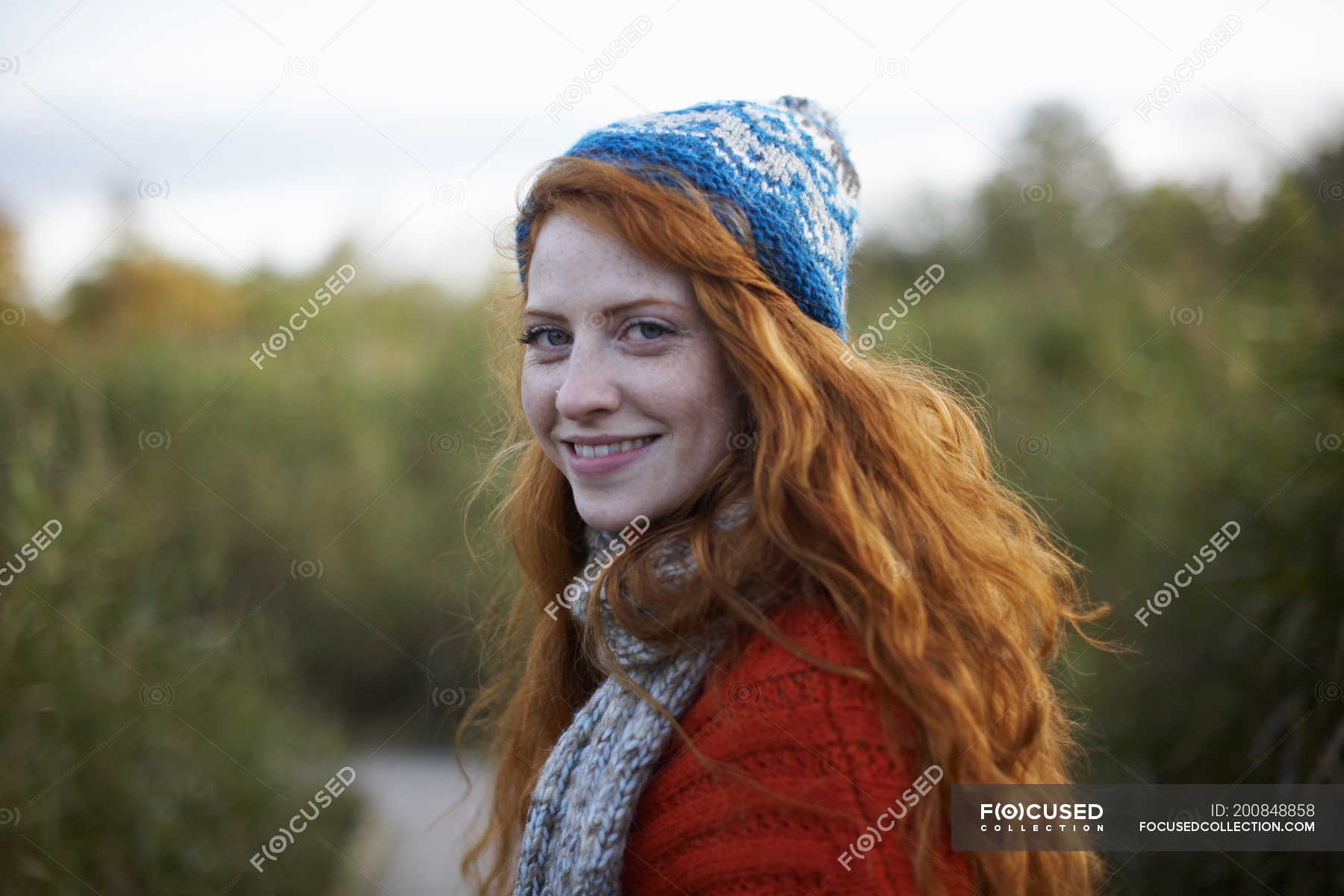 Portrait of red haired woman looking over shoulder at camera — 25 to 29 ...