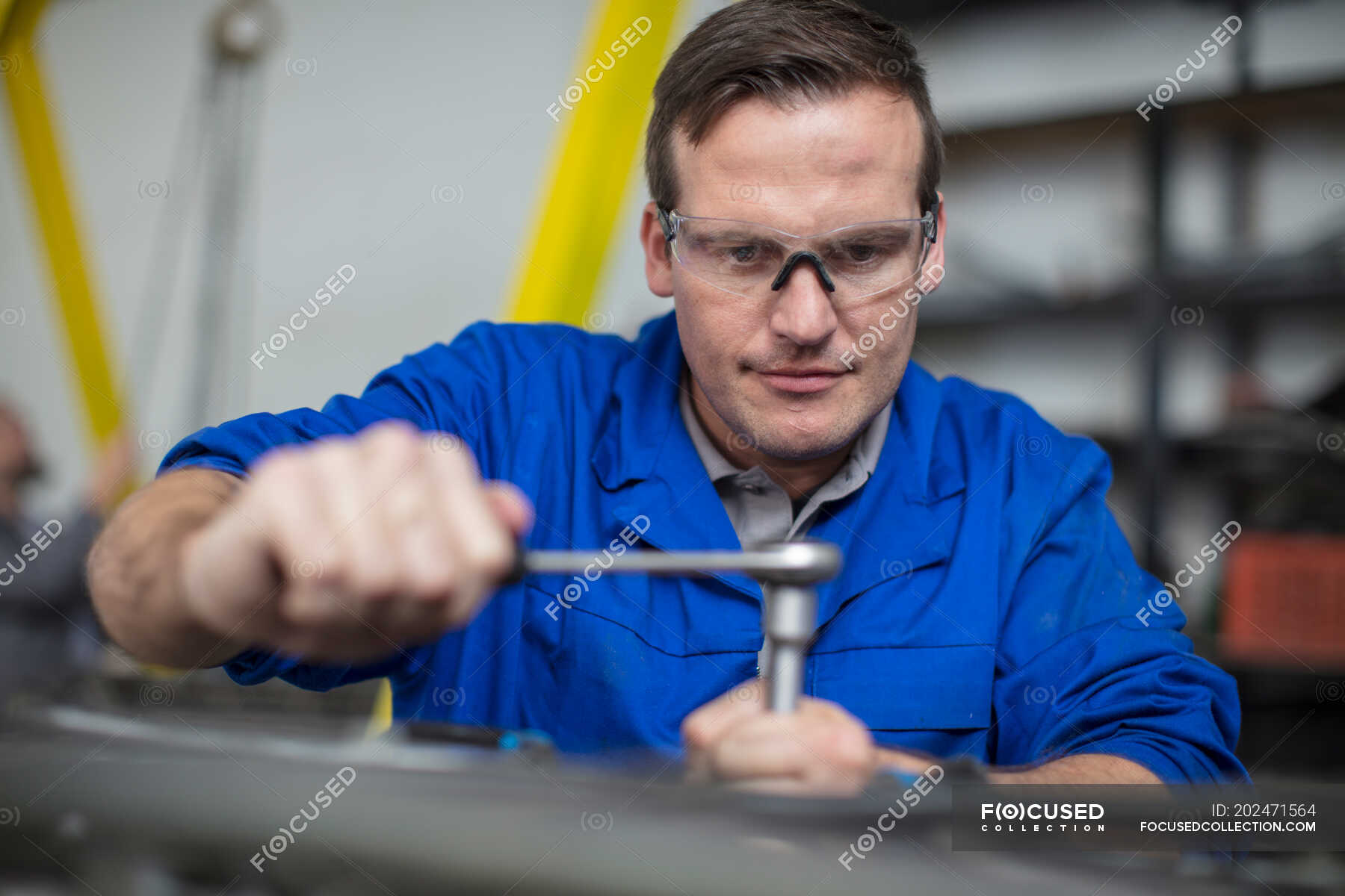 Male car mechanic using wrench in repair garage — Small Business ...