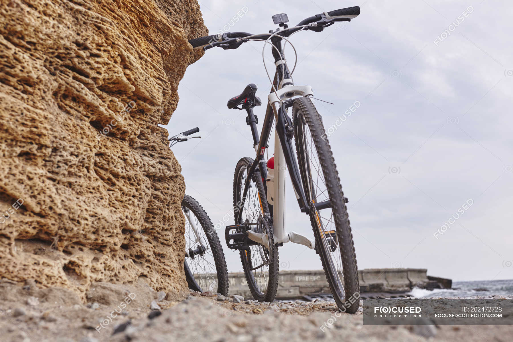 Bikes leaning against rock on beach, Odessa, Odeska Oblast, Ukraine ...