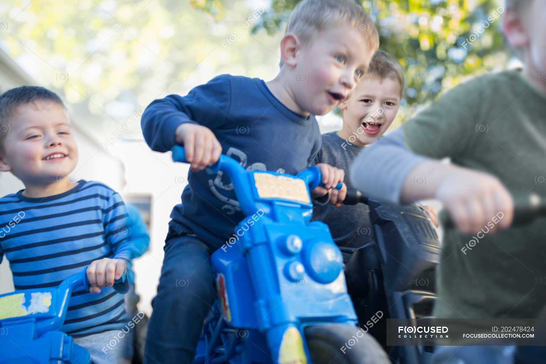 Boys at preschool racing push motorbikes in garden — day, Only Boys
