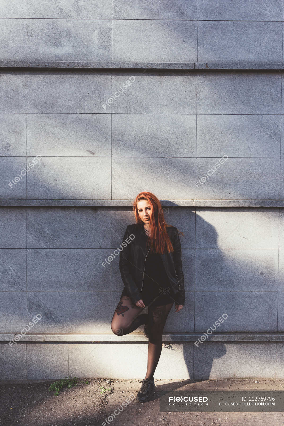 Portrait Of Red Haired Woman Leaning Against Wall Female On One Leg