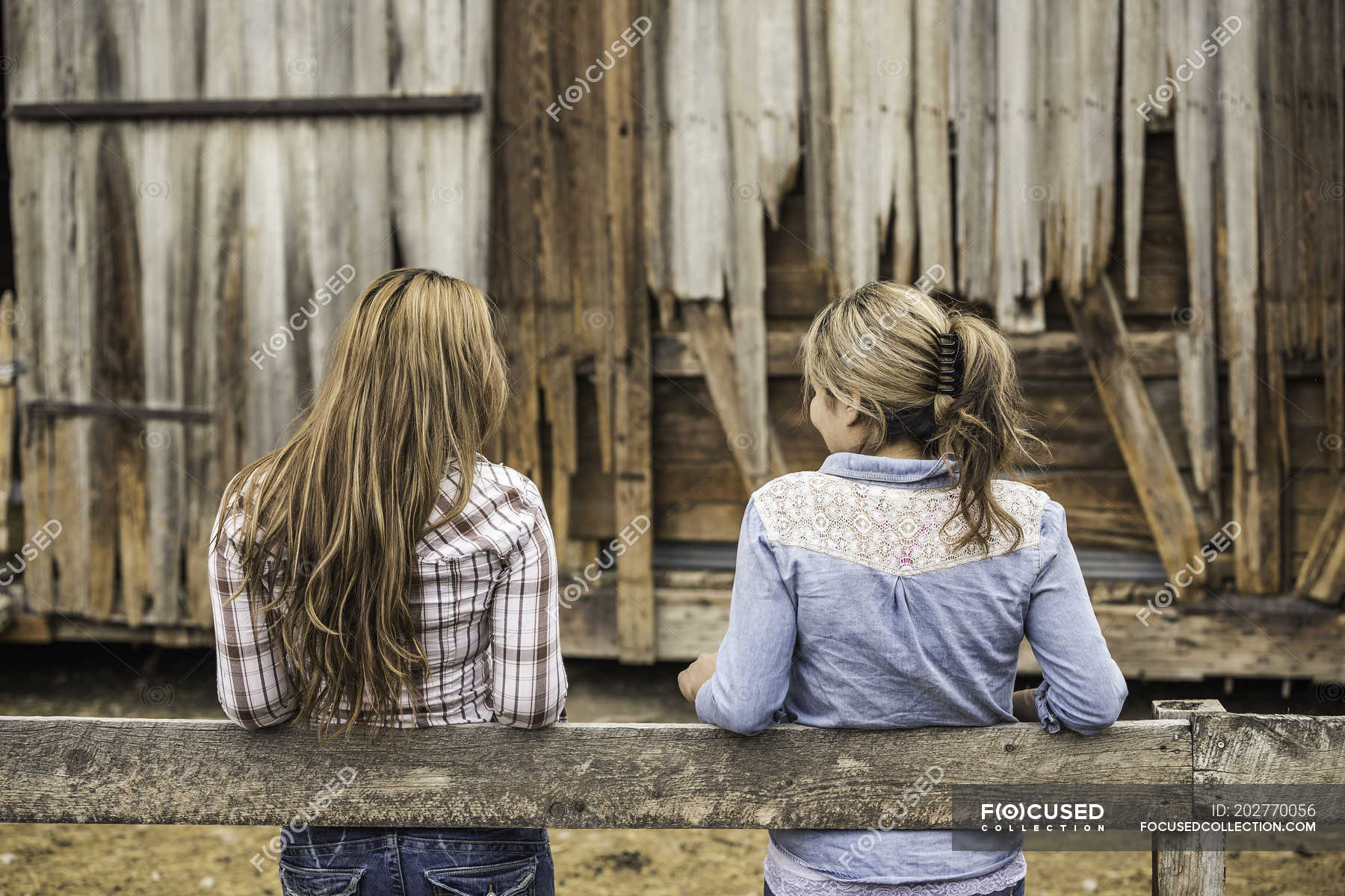 Two Young Women Leaning On Fence Rear View — Caucasian Ethnicity