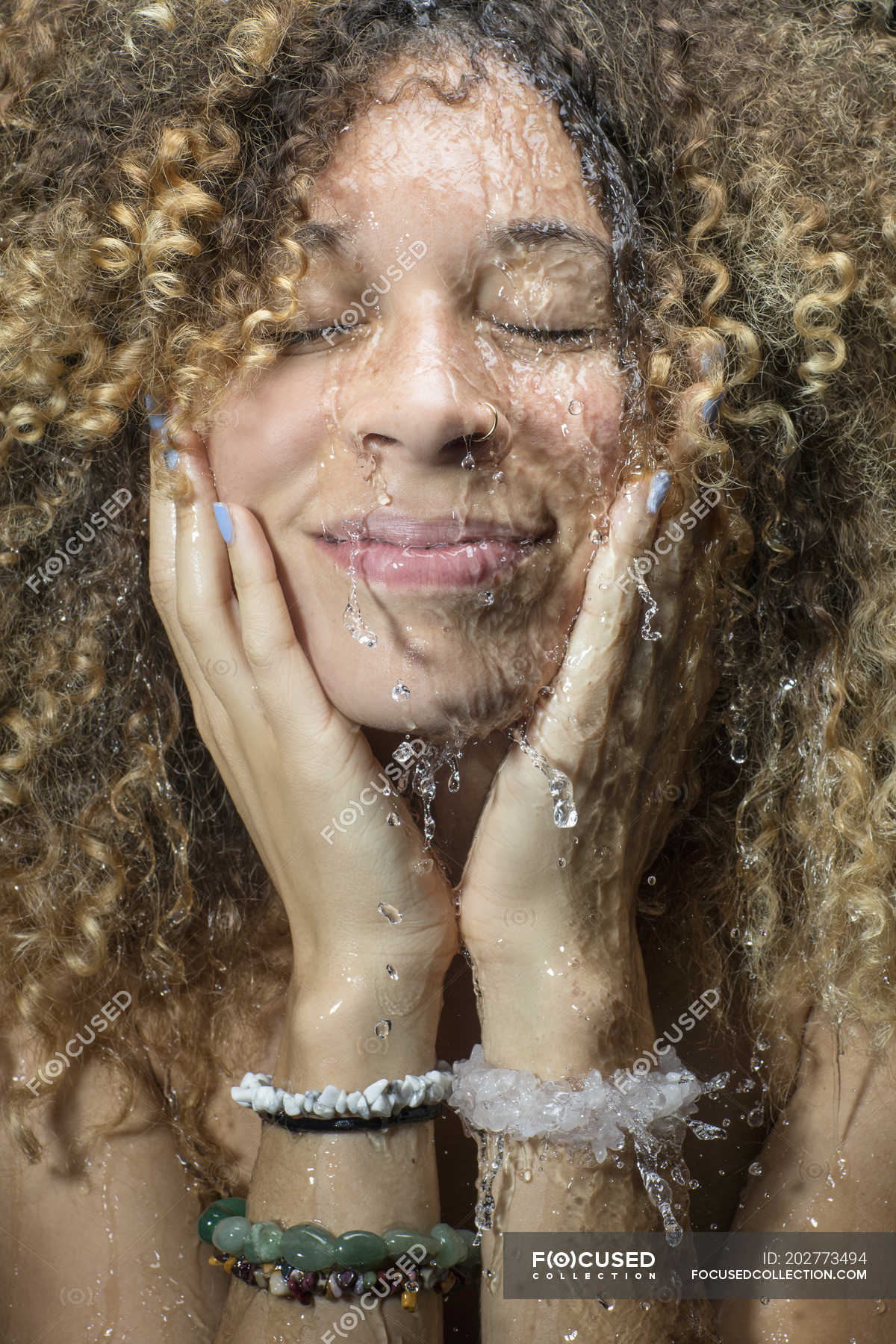 Woman splashing water on face — Studio Shot, dyed hair Stock Photo