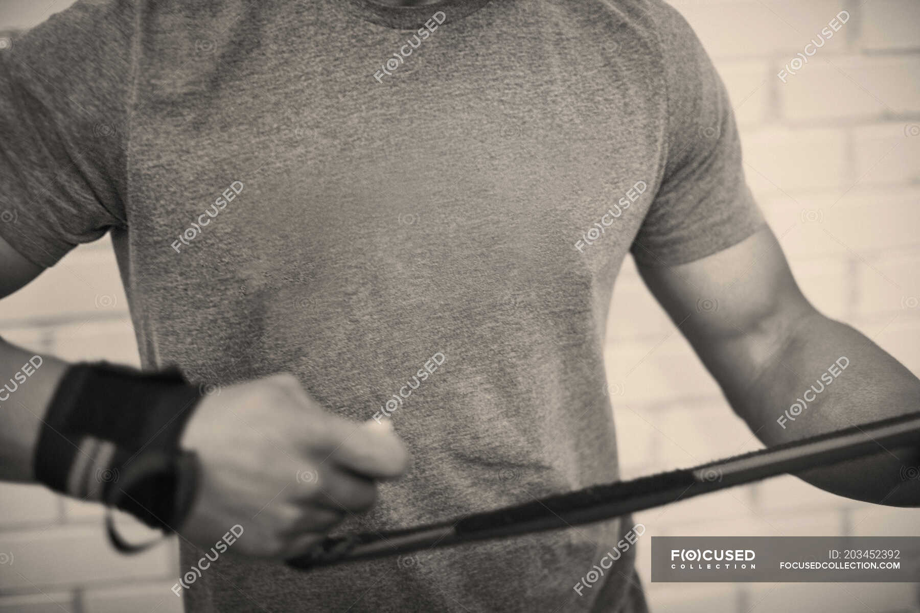 Cropped view of man strapping hands with weightlifting straps — african