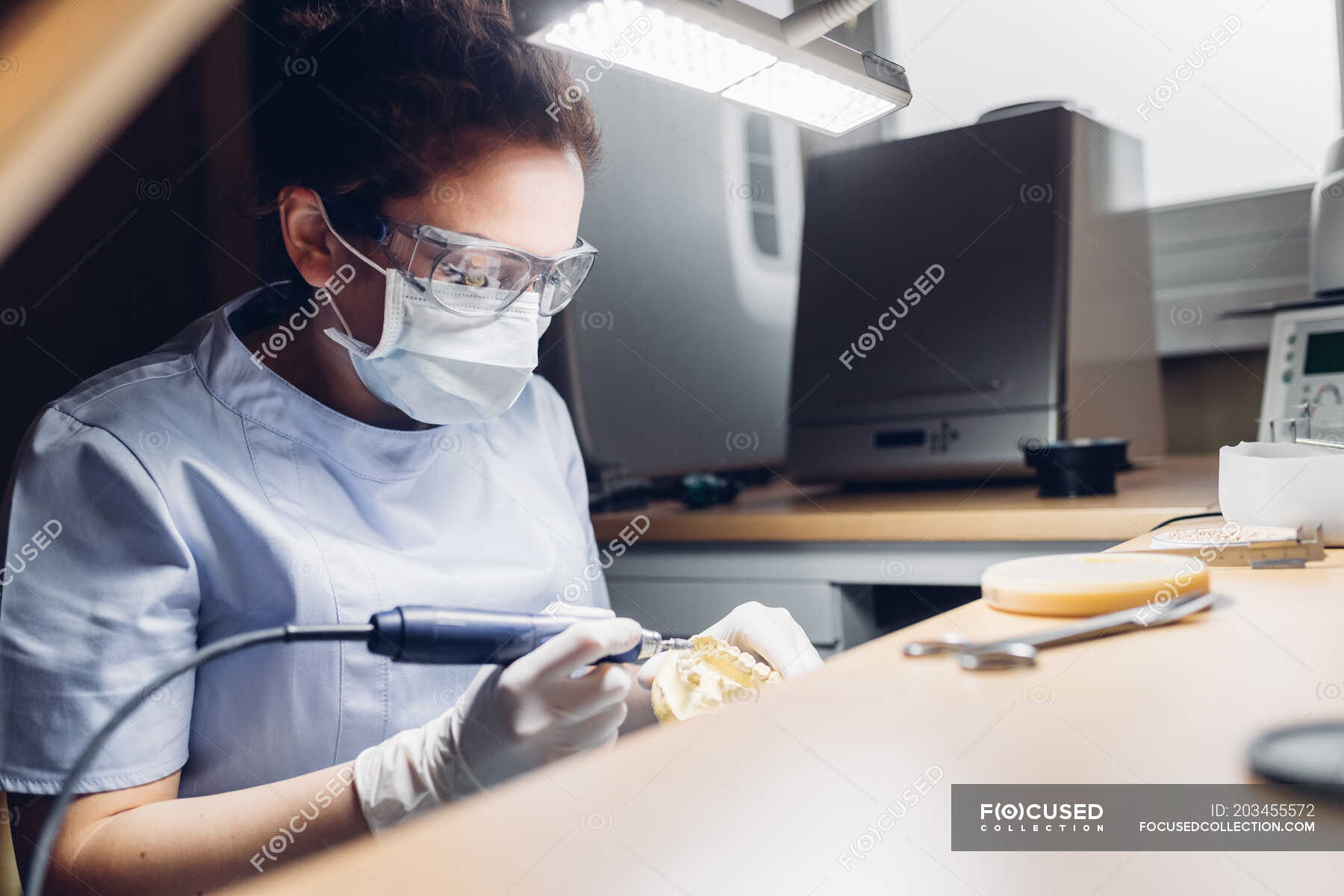 Dentist making denture in laboratory — indoors, sitting Stock Photo