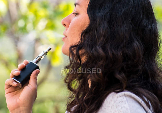 Mature moking electronic cigarette — Stock Photo