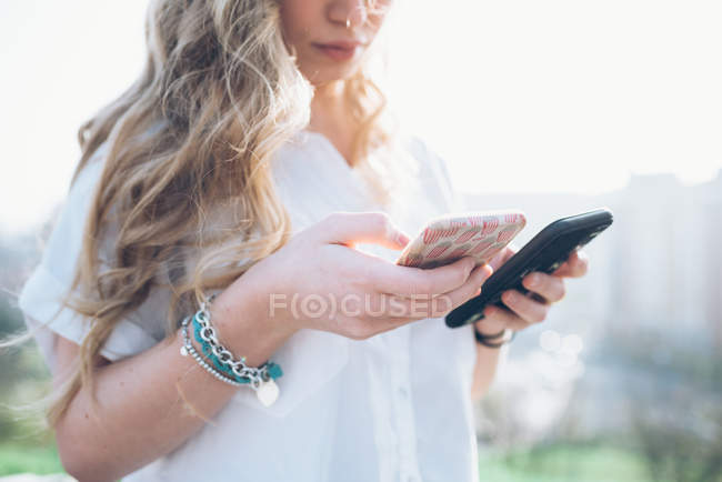 Woman looking at two smartphones — Stock Photo