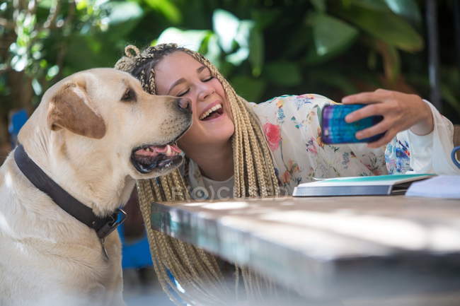 Jeune femme prenant selfie avec chien de compagnie — Photo de stock