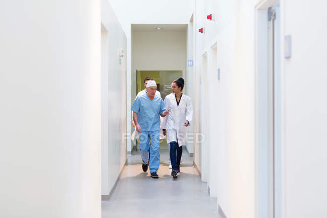 Doctors walking through hospital corridor — Stock Photo