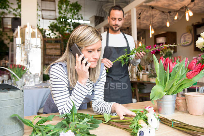 Female florist talking on smartphone — Stock Photo