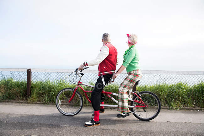 Couple regardant du vélo tandem à la côte — Photo de stock