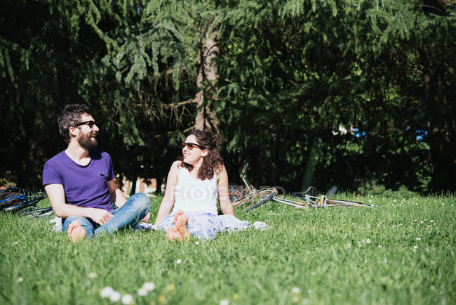 Casal sentado conversando no parque — Fotografia de Stock
