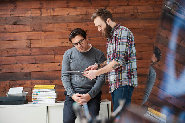 Male designers pointing at digital tablet — Stock Photo