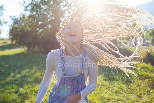 Woman with long plaited hair in field — Stock Photo