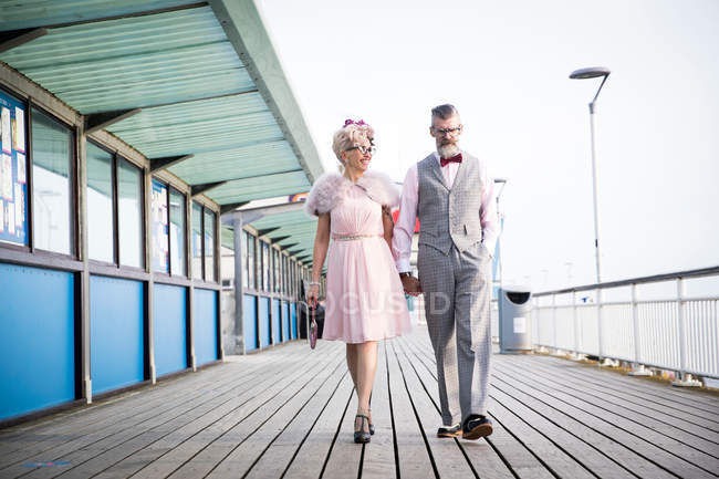 Couple strolling and holding hands on pier — Stock Photo